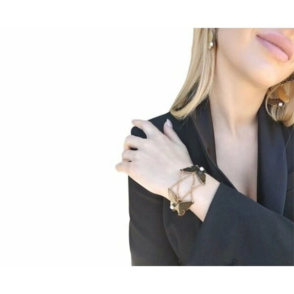 Χειρόγραφο χειροποίητο βραχιόλι πεταλούδα - 3016, Το χειρόγραφο χειροποίητο βραχιόλι με πεταλούδα αποτελεί ένα μοναδικό κόσμημα που συνδυάζει την κομψότητα της φύσης με τη σύγχρονη αισθητική. Σχεδιασμένο από την Ελληνίδα Σχεδιάστρια Κοσμημάτων Αικατερίνη Χαλκιαδάκη, αυτό το εντυπωσιακό γυναικείο βραχιόλι διαθέτει δύο λεπτομερείς πεταλούδες από ορείχαλκο με μαύρη πατίνα που τους προσδίδει vintage χαρακτήρα.
Οι πεταλούδες συνδέονται με λεπτή αλυσίδα από ορείχαλκο και διακοσμούνται με λευκά μαργαριτάρια που προσθέτουν μια νότα κομψότητας και φωτεινότητας. Η μαύρη πατίνα δημιουργεί όμορφες αντιθέσεις χρωμάτων, ενώ η χειρόγραφη τεχνική κατασκευής κάνει κάθε κομμάτι μοναδικό.
Το βραχιόλι είναι ιδανικό για καθημερινή χρήση ή για ειδικές περιστάσεις, προσθέτοντας έναν καλλιτεχνικό χαρακτήρα σε κάθε εμφάνιση. Συνδυάζεται τέλεια με άλλα χειροποίητα κοσμήματα και αποτελεί μια υπέροχη επιλογή δώρου για γυναίκες που εκτιμούν την ελληνική τέχνη και το χειροποίητο κόσμημα.