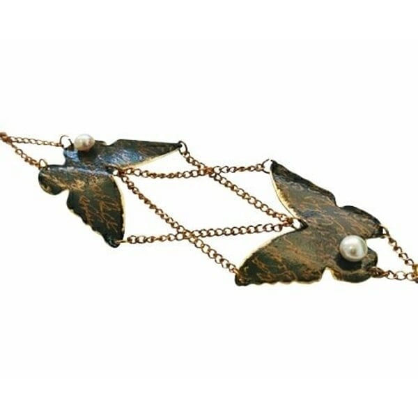 Χειρόγραφο χειροποίητο βραχιόλι πεταλούδα - 3016, Το χειρόγραφο χειροποίητο βραχιόλι με πεταλούδα αποτελεί ένα μοναδικό κόσμημα που συνδυάζει την κομψότητα της φύσης με τη σύγχρονη αισθητική. Σχεδιασμένο από την Ελληνίδα Σχεδιάστρια Κοσμημάτων Αικατερίνη Χαλκιαδάκη, αυτό το εντυπωσιακό γυναικείο βραχιόλι διαθέτει δύο λεπτομερείς πεταλούδες από ορείχαλκο με μαύρη πατίνα που τους προσδίδει vintage χαρακτήρα.
Οι πεταλούδες συνδέονται με λεπτή αλυσίδα από ορείχαλκο και διακοσμούνται με λευκά μαργαριτάρια που προσθέτουν μια νότα κομψότητας και φωτεινότητας. Η μαύρη πατίνα δημιουργεί όμορφες αντιθέσεις χρωμάτων, ενώ η χειρόγραφη τεχνική κατασκευής κάνει κάθε κομμάτι μοναδικό.
Το βραχιόλι είναι ιδανικό για καθημερινή χρήση ή για ειδικές περιστάσεις, προσθέτοντας έναν καλλιτεχνικό χαρακτήρα σε κάθε εμφάνιση. Συνδυάζεται τέλεια με άλλα χειροποίητα κοσμήματα και αποτελεί μια υπέροχη επιλογή δώρου για γυναίκες που εκτιμούν την ελληνική τέχνη και το χειροποίητο κόσμημα.