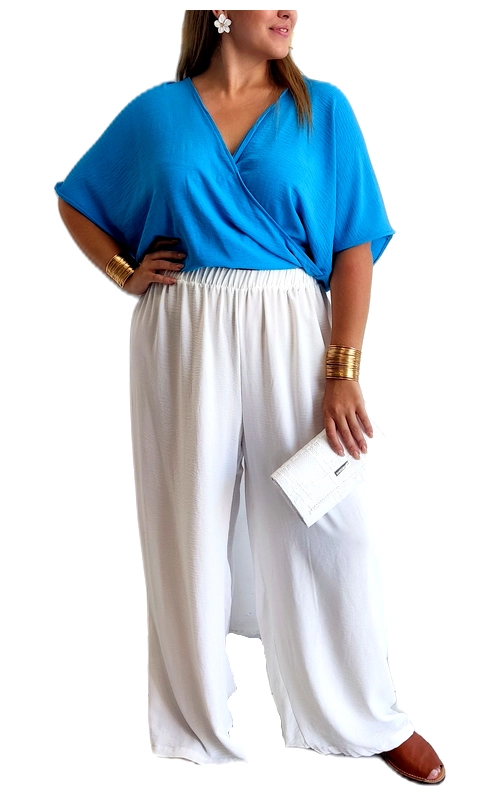 Αυτό το εντυπωσιακό σύνολο plus size αποτελείται από ένα κομψό κροπ τοπ σε λαμπερό γαλάζιο χρώμα και μια άνετη παντελόνα σε λευκό. Το τοπ διαθέτει κρουαζέ σχεδιασμό με V λαιμόκοψη που κολακεύει το μπούστο, ενώ τα φαρδιά, αναδιπλούμενα μανίκια προσφέρουν άνεση και στυλ. Η ελαφριά υφή του υφάσματος είναι ιδανική για τις ζεστές καλοκαιρινές ημέρες. Συνδυάζεται αρμονικά με την αέρινη λευκή παντελόνα που διαθέτει ελαστική μέση για άψογη εφαρμογή και άνετη κίνηση. Αυτό το σύνολο είναι ιδανικό για καλοκαιρινές βραδινές εξόδους, κοκτέιλ πάρτι ή ακόμα και για πιο επίσημες καλοκαιρινές εκδηλώσεις. Μπορεί να συνδυαστεί με χρυσά κοσμήματα όπως αυτά που φαίνονται στην εικόνα, και με μια κομψή τσάντα\u002Dφάκελο για ολοκληρωμένο στυλ. Το σύνολο προσφέρει την τέλεια ισορροπία μεταξύ κομψότητας και άνεσης, αναδεικνύοντας τις καμπύλες σας με τον πιο κολακευτικό τρόπο.