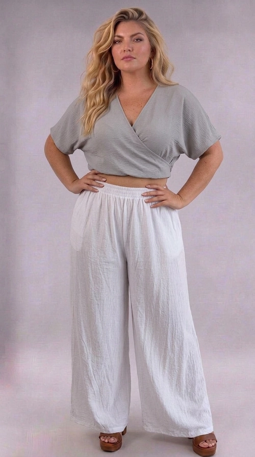 Κροπ τοπ γκρι καλοκαιρινό plus size - CTSPL124 | Candiashop Boutique, Ανακαλύψτε το απόλυτο καλοκαιρινό κροπ τοπ που συνδυάζει στυλ και άνεση σε μία μοναδική δημιουργία. Σε ελκυστική γκρι-ασημί απόχρωση, το τοπ αυτό διαθέτει κομψό κρουαζέ ντεκολτέ σε σχήμα V, που χαρίζει μια θηλυκή και σαγηνευτική σιλουέτα. Οι φαρδιές κοντές μανσέτες προσφέρουν μια χαλαρή, boho αισθητική, ενώ το ελαφρύ, υφαντό ύφασμα με διακριτή υφή εξασφαλίζει αναπνεύσιμη άνεση τις ζεστές καλοκαιρινές μέρες. Ιδανικό για plus size σώματα, το κροπ τοπ αυτό αγκαλιάζει τις καμπύλες σας με χάρη και αυτοπεποίθηση. Μπορεί να φορεθεί με φαρδιές λευκές παντελόνες για ένα ολοκληρωμένο καλοκαιρινό σύνολο, όπως φαίνεται στη φωτογραφία, αλλά και με ψηλόμεσα τζιν, φλοράλ φούστες ή σορτς για διαφορετικές περιστάσεις. Κατάλληλο για βόλτες στην παραλία, καλοκαιρινές εξόδους ή χαλαρές συναντήσεις με φίλους, αυτό το κομμάτι αποτελεί must-have προσθήκη στη θερινή σας γκαρνταρόμπα.