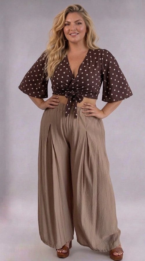 Κροπ τοπ καφέ καλοκαιρινό plus size - CTSPL128 | Candiashop Boutique, Ανακαλύψτε το απόλυτο καλοκαιρινό κροπ τοπ που συνδυάζει στυλ και άνεση για κάθε plus size σιλουέτα. Σε βαθύ καφέ χρώμα σοκολάτας με χαριτωμένα μπεζ πουά, αυτό το τοπ αναδεικνύει τη θηλυκότητα με τον πιο κομψό τρόπο. Το V-λαιμόκοψη και το δέσιμο στο μπροστινό μέρος δημιουργούν μια κολακευτική εφαρμογή που τονίζει τη μέση, ενώ τα μεσαία μανίκια προσθέτουν έναν αέρα ρομαντισμού. Το ελαφρύ, ρέον ύφασμα εξασφαλίζει άνεση σε ζεστές μέρες, κάνοντάς το ιδανικό για καλοκαιρινές εξόδους, βόλτες στην παραλία ή καφεδάκι με φίλες. Μπορεί να συνδυαστεί τέλεια με φαρδιά παντελόνια σε μπεζ ή χακί τόνους, όπως φαίνεται στη φωτογραφία, αλλά και με ψηλόμεσα τζιν ή φούστες midi για ένα ολοκληρωμένο look. Ένα must-have κομμάτι για τη γυναίκα που αγαπά τη μόδα χωρίς συμβιβασμούς!