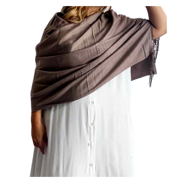 Αυτή η κομψή εσάρπα σε απόχρωση καφέ\u002Dγκρι (ταμπά) αποτελεί ένα αριστοκρατικό αξεσουάρ για κάθε γυναικεία γκαρνταρόμπα. Κατασκευασμένη από πολυτελές μείγμα 90% κασμίρ και 10% μετάξι, προσφέρει εξαιρετική απαλότητα και μια ανεπαίσθητη λάμψη που αναδεικνύει την ποιότητά της. Το γενναιόδωρο μέγεθός της επιτρέπει να τυλιχτεί με διάφορους τρόπους γύρω από τους ώμους, δημιουργώντας πλούσιες πτυχώσεις και κομψή εμφάνιση. Η εσάρπα διαθέτει διακριτικά κρόσσια στις άκρες, που προσθέτουν μια νότα κομψότητας, ενώ ο μονόχρωμος σχεδιασμός της την καθιστά εύκολα συνδυάσιμη με οποιοδήποτε ένδυμα. Ιδανική για επίσημες βραδινές εμφανίσεις, συνδυάζεται τέλεια με λευκά φορέματα, όπως απεικονίζεται, αλλά και με μαύρα, μπεζ ή ακόμη και έντονα χρώματα για εντυπωσιακή αντίθεση. Είναι το τέλειο αξεσουάρ για γάμους, επίσημα δείπνα ή θεατρικές παραστάσεις, προσφέροντας παράλληλα ζεστασιά και στυλ. Η εξαιρετική ποιότητα των υλικών της εγγυάται διαχρονική χρήση και ανθεκτικότητα.