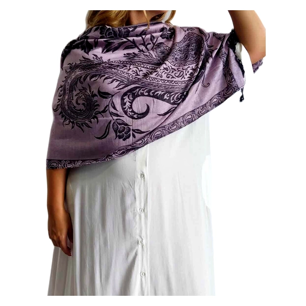 Αυτή η κομψή εσάρπα σε απαλό μοβ χρώμα (λιλά) αποτελεί ένα εξαιρετικό αξεσουάρ για κάθε γυναικεία γκαρνταρόμπα. Κατασκευασμένη από πολυτελή συνδυασμό 90% κασμίρ και 10% μετάξι, προσφέρει απαράμιλλη απαλότητα και ζεστασιά με μια μεταξένια αίσθηση που αγκαλιάζει τους ώμους σας. Το εντυπωσιακό μαύρο διακοσμητικό μοτίβο με φυτικά και περίτεχνα σχέδια προσθέτει μια αριστοκρατική πινελιά στο σύνολο. Η εσάρπα είναι αρκετά μεγάλη ώστε να μπορεί να φορεθεί με διάφορους τρόπους \u002D ριχτή στους ώμους, τυλιγμένη γύρω από το λαιμό ή ακόμα και ως κομψό σάλι για βραδινές εξόδους. Συνδυάζεται τέλεια με απλά μονόχρωμα φορέματα όπως το λευκό της φωτογραφίας, αλλά και με επίσημα ή καθημερινά σύνολα. Ιδανική για θεατρικές παραστάσεις, επίσημα δείπνα ή ακόμα και για μια κομψή καθημερινή εμφάνιση. Η υψηλή ποιότητα των υλικών εγγυάται διάρκεια στο χρόνο, ενώ το διαχρονικό σχέδιο την καθιστά ένα αξεσουάρ που δεν θα βγει ποτέ από τη μόδα.