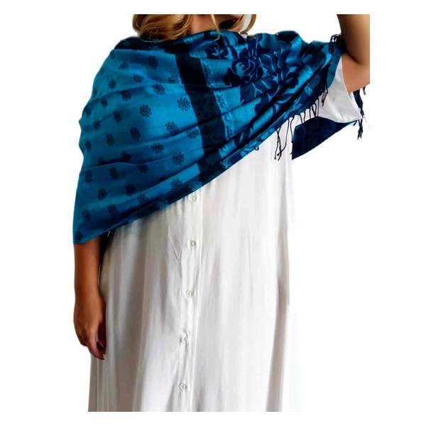 Αυτή η εντυπωσιακή εσάρπα σε πλούσιο βαθύ κυανό χρώμα αποτελεί ένα αριστοτεχνικό κομμάτι πολυτέλειας, κατασκευασμένο από 90% κασμίρ και 10% μετάξι. Το λεπτεπίλεπτο μοτίβο με τα διάσπαρτα γεωμετρικά σχέδια σε σκούρο μπλε δημιουργεί μια κομψή αντίθεση στη λαμπερή επιφάνεια του υφάσματος. Οι κρόσσια στις άκρες προσθέτουν μια πινελιά κλασικής κομψότητας, ενώ η απαλή υφή χαρίζει μια αίσθηση πολυτέλειας στο άγγιγμα. Ιδανική για βραδινές εξόδους, επίσημες εκδηλώσεις ή ακόμη και για να αναβαθμίσετε ένα απλό καθημερινό σύνολο. Συνδυάζεται τέλεια με λευκά ή μονόχρωμα φορέματα, όπως φαίνεται στην εικόνα, αλλά και με κομψά παντελόνια ή φούστες. Το μέγεθός της επιτρέπει πολλαπλούς τρόπους στυλιζαρίσματος – φορέστε την ως παραδοσιακή εσάρπα, ως φαρδύ κασκόλ ή ως ελαφρύ σάλι για τους δροσερούς καλοκαιρινούς βραδινούς περιπάτους. Η εξαιρετική ποιότητα των υλικών εξασφαλίζει ζεστασιά, απαλότητα και διαχρονική κομψότητα που θα σας συντροφεύει για πολλές σεζόν.