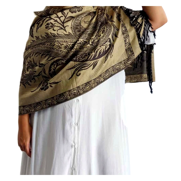 Αυτή η εκλεπτυσμένη εσάρπα από 90% κασμίρ και 10% μετάξι αποτελεί ένα αριστουργηματικό αξεσουάρ για την γκαρνταρόμπα σας. Σε μια πλούσια απόχρωση χακί\u002Dμπεζ με εντυπωσιακά μαύρα σχέδια, η εσάρπα διαθέτει περίτεχνα φλοράλ και παϊσλεϊ μοτίβα που αναδεικνύουν την πολυτελή της υφή. Οι κομψές κρόσσες στις άκρες προσθέτουν μια νότα ραφιναρισμένης κομψότητας, ενώ οι λεπτομερείς διακοσμητικές γραμμές περιμετρικά ολοκληρώνουν το σχέδιο με μοναδικό τρόπο. Η απαλή υφή του κασμίρ σε συνδυασμό με την αίσθηση του μεταξιού προσφέρει εξαιρετική άνεση και πολυτελή αίσθηση στο δέρμα. Φορέστε την ριχτή στους ώμους πάνω από ένα λευκό φόρεμα όπως στην εικόνα, ή συνδυάστε την με μαύρο φόρεμα για βραδινές εξόδους. Ιδανική για επίσημες περιστάσεις, κοκτέιλ πάρτι ή για να προσθέσετε μια πινελιά κομψότητας σε ένα καθημερινό σύνολο. Η ευελιξία της επιτρέπει να φορεθεί ως εσάρπα, σάλι ή ακόμη και ως διακοσμητικό στοιχείο σε μια τσάντα, προσφέροντας απεριόριστες επιλογές στυλιζαρίσματος.