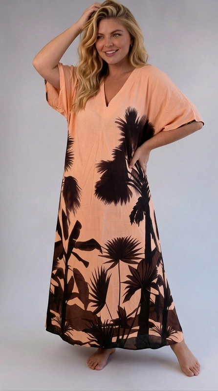 Φόρεμα κρεμ καλοκαιρινό - FRW712 | Candiashop Boutique, Ένα εντυπωσιακό maxi φόρεμα τύπου kaftan που συνδυάζει το ροδακινί χρώμα με σκούρες καφέ-μαύρες σιλουέτες τροπικής βλάστησης, δημιουργώντας ένα αποτέλεσμα που παραπέμπει σε εξωτικά τοπία. Το μοτίβο αποτελείται από φοίνικες, τροπικά φύλλα και βλάστηση που καλύπτουν το κάτω μέρος και τα πλαϊνά του φορέματος, αφήνοντας το πάνω τμήμα πιο καθαρό και φωτεινό. Το φόρεμα διαθέτει λαιμόκοψη σε σχήμα V, φαρδιά κοντά μανίκια τύπου batwing και ελεύθερη, ρέουσα γραμμή που χαρίζει άνεση και κομψότητα. Η κοπή του είναι ιδιαίτερα κολακευτική για plus size σιλουέτες, καθώς αναδεικνύει τις καμπύλες χωρίς να σφίγγει. Ιδανικό για καλοκαιρινές διακοπές, βόλτες στην παραλία ή ως beach cover-up, αλλά και για χαλαρές καλοκαιρινές βραδιές. Μπορεί να συνδυαστεί με σανδάλια και ψάθινη τσάντα για ένα ολοκληρωμένο summer look που δεν περνά απαρατήρητο.
