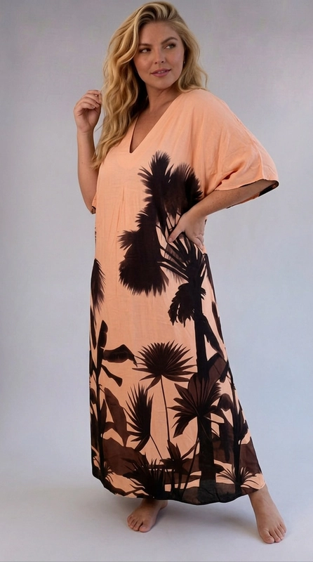 Φόρεμα κρεμ καλοκαιρινό - FRW712 | Candiashop Boutique, Ένα εντυπωσιακό maxi φόρεμα τύπου kaftan που συνδυάζει το ροδακινί χρώμα με σκούρες καφέ-μαύρες σιλουέτες τροπικής βλάστησης, δημιουργώντας ένα αποτέλεσμα που παραπέμπει σε εξωτικά τοπία. Το μοτίβο αποτελείται από φοίνικες, τροπικά φύλλα και βλάστηση που καλύπτουν το κάτω μέρος και τα πλαϊνά του φορέματος, αφήνοντας το πάνω τμήμα πιο καθαρό και φωτεινό. Το φόρεμα διαθέτει λαιμόκοψη σε σχήμα V, φαρδιά κοντά μανίκια τύπου batwing και ελεύθερη, ρέουσα γραμμή που χαρίζει άνεση και κομψότητα. Η κοπή του είναι ιδιαίτερα κολακευτική για plus size σιλουέτες, καθώς αναδεικνύει τις καμπύλες χωρίς να σφίγγει. Ιδανικό για καλοκαιρινές διακοπές, βόλτες στην παραλία ή ως beach cover-up, αλλά και για χαλαρές καλοκαιρινές βραδιές. Μπορεί να συνδυαστεί με σανδάλια και ψάθινη τσάντα για ένα ολοκληρωμένο summer look που δεν περνά απαρατήρητο.