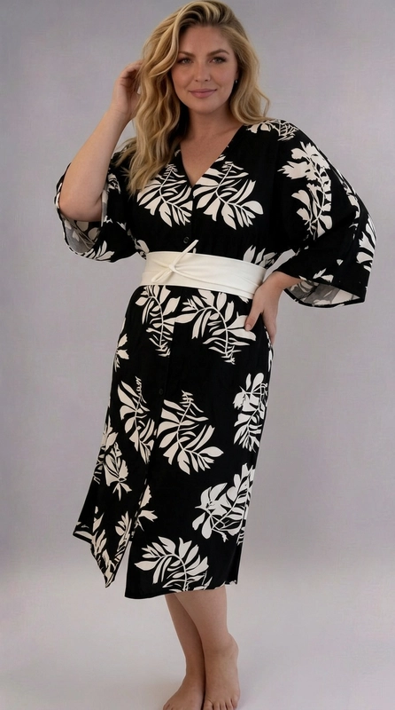 Φόρεμα μαύρο καλοκαιρινό - FRW683 | Candiashop Boutique, Ένα εντυπωσιακό φόρεμα plus size που συνδυάζει στυλ και άνεση με αψεγάδιαστο τρόπο. Το μαύρο φόντο του αναδεικνύει το υπέροχο μοτίβο με φύλλα σε κρεμ-εκρού απόχρωση, δημιουργώντας ένα τολμηρό και μοντέρνο αποτέλεσμα. Το φόρεμα διαθέτει γραμμή kimono με φαρδιά μανίκια τριών τετάρτων, που χαρίζουν μια αέρινη, boho αίσθηση. Το κλείσιμο με κουμπιά στο μπροστινό μέρος και η V-λαιμόκοψη προσθέτουν έναν κομψό χαρακτήρα, ενώ η κρεμ-εκρού ζώνη obi στη μέση ορίζει τη σιλουέτα και δίνει έμφαση στις καμπύλες με κολακευτικό τρόπο. Το midi μήκος του εξασφαλίζει κάλυψη και κομψότητα ταυτόχρονα. Ιδανικό για καλοκαιρινές εξόδους, βραδινές εκδηλώσεις ή ακόμα και για μια χαλαρή ημέρα στην παραλία. Μπορεί να φορεθεί με σανδάλια για casual εμφάνιση ή με πέδιλα για πιο επίσημες περιστάσεις. Ένα φόρεμα που αγκαλιάζει κάθε σώμα με χάρη και αυτοπεποίθηση.