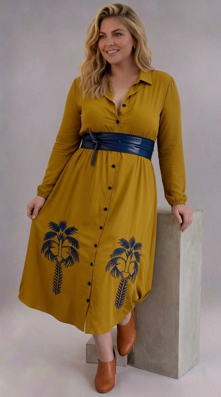 Φόρεμα πράσινο καλοκαιρινό - FRW694 | Candiashop Boutique, Ένα εντυπωσιακό φόρεμα σε βαθύ ώχρα-μουσταρδί χρώμα που αναδεικνύει τη θηλυκή σιλουέτα με στιλ και κομψότητα. Το σχέδιό του διαθέτει κλασικό γιακά πουκαμίσου και κουμπιά που διατρέχουν κατακόρυφα το μπροστινό μέρος, δίνοντας έναν εκλεπτυσμένο, vintage χαρακτήρα. Το αποκορύφωμα του σχεδιασμού είναι τα μοναδικά μοτίβα φοινικόδεντρων, τοποθετημένα συμμετρικά στο κάτω τμήμα, που προσδίδουν έναν εξωτικό, τροπικό τόνο. Το φόρεμα διαθέτει μακριά μανίκια και midi μήκος, ενώ η γραμμή empire με τη φαρδιά ζώνη τονίζει τη μέση και δημιουργεί κολακευτική εφαρμογή για plus size σώματα. Η φαρδιά φούστα εξασφαλίζει άνεση και ελευθερία κινήσεων. Μπορεί να φορεθεί σε καλοκαιρινές εκδρομές, ημερήσιες εξόδους ή και σε πιο επίσημες περιστάσεις. Συνδυάστε το με κάστανα μποτάκια ή σανδάλια για ένα ολοκληρωμένο, τάσης αποτέλεσμα.