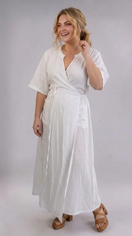 Φόρεμα άσπρο καλοκαιρινό - FRW809 | Candiashop Boutique, Ένα υπέροχο φόρεμα σε λευκό χρώμα που αναδεικνύει την ομορφιά κάθε γυναίκας, ιδανικό για plus size σιλουέτες. Το wrap στυλ του με το χαρακτηριστικό V-λαιμόκοψη δημιουργεί μια κομψή και κολακευτική εφαρμογή, ενώ η υφή του υφάσματος, που θυμίζει λινό, προσδίδει ένα αέρινο και φυσικό χαρακτήρα. Το φόρεμα διαθέτει κοντά μανίκια σε στυλ κιμονό, που χαρίζουν άνεση και ελευθερία κινήσεων, καθώς και ένα λεπτό ζωνάκι στη μέση που τονίζει τις καμπύλες. Το μάξι μήκος του, που φτάνει έως τον αστράγαλο, το καθιστά ιδανικό για κάθε περίσταση. Μια εξαιρετική επιλογή για καλοκαιρινές βόλτες, παραλία, καλοκαιρινά πάρτι ή ακόμα και για πιο επίσημες εξόδους. Μπορεί να συνδυαστεί τέλεια με καφέ πλατφόρμες ή σανδάλια, όπως φαίνεται στη φωτογραφία, αλλά και με χρυσά αξεσουάρ για ένα ολοκληρωμένο, θηλυκό αποτέλεσμα. Ένα διαχρονικό κομμάτι που δεν πρέπει να λείπει από καμία γκαρνταρόμπα.
