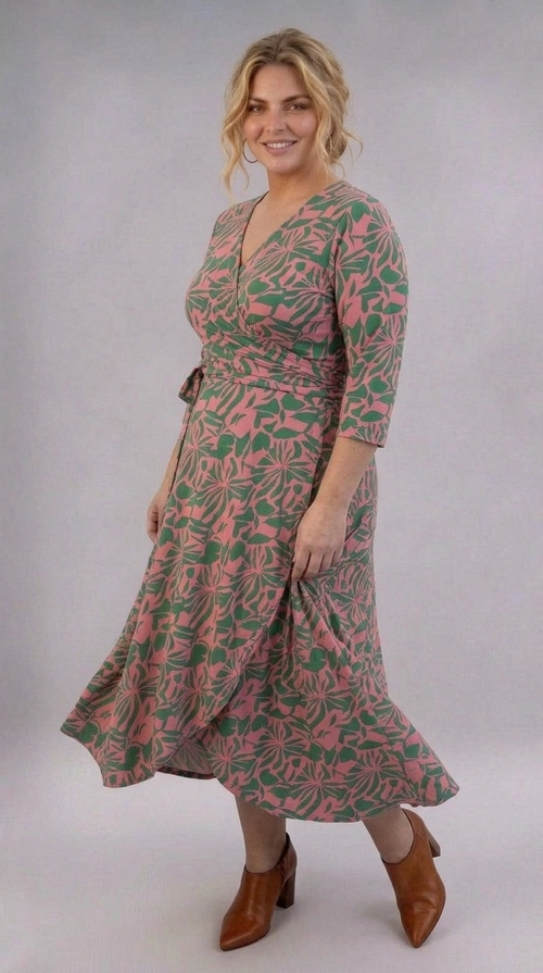 Φόρεμα ροζ χειμωνιάτικο - FRW811 | Candiashop Boutique, Ένα υπέροχο φόρεμα κρουαζέ που συνδυάζει στυλ και άνεση, ιδανικό για γυναίκες plus size που αγαπούν τη θηλυκή αισθητική. Το εντυπωσιακό του μοτίβο αποτελείται από έντονα φυτικά και floral σχέδια σε συνδυασμό ροζ σομόν και βαθύ πράσινο χρώμα, δημιουργώντας μια ζωντανή και χαρούμενη εμφάνιση. Το φόρεμα διαθέτει κλείσιμο κρουαζέ στο μπούστο με ζώνη που δένει στη μέση, τονίζοντας κομψά τη σιλουέτα. Τα τρία τέταρτα μανίκια προσφέρουν κομψότητα και άνεση, ενώ η midi γραμμή του φούστας με την ελαφρώς ασύμμετρη πτώση προσδίδει κίνηση και χάρη. Η εφαρμογή του είναι ρευστή και κολακευτική για κάθε σώμα. Μπορεί να φορεθεί σε επαγγελματικά ραντεβού, σε γεύματα, σε καλοκαιρινές εκδηλώσεις ή σε βόλτες. Συνδυάζεται τέλεια με καφέ κογιάκ μποτάκια με τακούνι, όπως στη φωτογραφία, αλλά και με σανδάλια ή μπαλαρίνες για πιο casual εμφανίσεις.