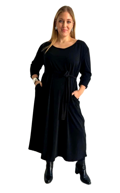 Αυτό το κομψό φόρεμα σε βαθύ μαύρο χρώμα αποτελεί την ιδανική επιλογή για τη χειμερινή σας γκαρνταρόμπα. Με την άνετη γραμμή του και το μεσαίο μήκος που φτάνει στη μέση της γάμπας, προσφέρει μια θηλυκή σιλουέτα που κολακεύει κάθε σωματότυπο. Το φόρεμα διαθέτει στρογγυλή λαιμόκοψη, μανίκια 3/4 και μια κομψή ζώνη στη μέση που τονίζει τη σιλουέτα και προσθέτει στυλ στο σύνολο. Η ρευστή, μαλακή ύφανση του υφάσματος εξασφαλίζει άνεση καθ\u0027 όλη τη διάρκεια της ημέρας, ενώ οι πρακτικές πλαϊνές τσέπες προσθέτουν λειτουργικότητα. Συνδυάστε το με μποτάκια για ένα καθημερινό chic look ή με ψηλοτάκουνα παπούτσια και εντυπωσιακά κοσμήματα για βραδινές εξόδους. Η ευελιξία του το καθιστά ιδανικό τόσο για το γραφείο όσο και για κοινωνικές περιστάσεις. Η διαχρονική του γραμμή και το κλασικό μαύρο χρώμα εγγυώνται πως θα παραμείνει αγαπημένο κομμάτι της συλλογής σας για πολλές σεζόν.