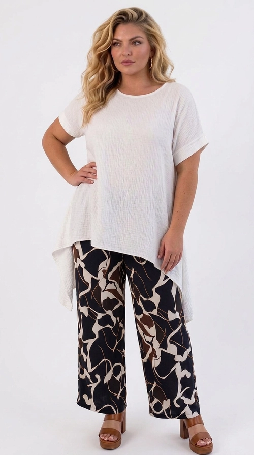 Παντελόνα γυναικεία εμπριμέ plus size - PANT200 | Candiashop Boutique, Η παντελόνα αυτή είναι η ιδανική επιλογή για κάθε γυναίκα που αναζητά στυλ και άνεση σε μεγάλα μεγέθη. Με βαθύ μαύρο φόντο και εντυπωσιακό floral μοτίβο σε αποχρώσεις εκρού και καφέ, δημιουργεί μια κομψή και θηλυκή εμφάνιση που ξεχωρίζει. Η φαρδιά γραμμή της και το ψηλόμεσο σχεδιασμό της αγκαλιάζουν τις καμπύλες με χάρη, προσφέροντας άψογη εφαρμογή και ελευθερία κινήσεων. Το ευρύχωρο πόδι της παντελόνας τη καθιστά ιδιαίτερα άνετη για καθημερινή χρήση, ενώ παράλληλα διατηρεί έναν έντονα μοντέρνο χαρακτήρα. Μπορεί να συνδυαστεί με λευκή κρεπ μπλούζα, όπως φαίνεται στη φωτογραφία, για ένα ολοκληρωμένο και αρμονικό σύνολο, ή εναλλακτικά με ένα απλό κρεμ ή μαύρο τοπ. Ιδανική για καλοκαιρινές εξόδους, επαγγελματικά γεύματα ή βόλτες στην πόλη, η παντελόνα αυτή συνδυάζει άψογα την κομψότητα με την καθημερινή πρακτικότητα, αποτελώντας must-have κομμάτι για κάθε γκαρνταρόμπα.