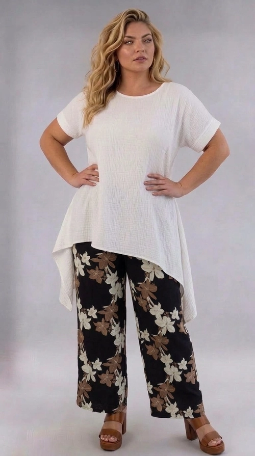 Παντελόνα γυναικεία εμπριμέ plus size - PANT200 | Candiashop Boutique, Η παντελόνα αυτή είναι η ιδανική επιλογή για κάθε γυναίκα που αναζητά στυλ και άνεση σε μεγάλα μεγέθη. Με βαθύ μαύρο φόντο και εντυπωσιακό floral μοτίβο σε αποχρώσεις εκρού και καφέ, δημιουργεί μια κομψή και θηλυκή εμφάνιση που ξεχωρίζει. Η φαρδιά γραμμή της και το ψηλόμεσο σχεδιασμό της αγκαλιάζουν τις καμπύλες με χάρη, προσφέροντας άψογη εφαρμογή και ελευθερία κινήσεων. Το ευρύχωρο πόδι της παντελόνας τη καθιστά ιδιαίτερα άνετη για καθημερινή χρήση, ενώ παράλληλα διατηρεί έναν έντονα μοντέρνο χαρακτήρα. Μπορεί να συνδυαστεί με λευκή κρεπ μπλούζα, όπως φαίνεται στη φωτογραφία, για ένα ολοκληρωμένο και αρμονικό σύνολο, ή εναλλακτικά με ένα απλό κρεμ ή μαύρο τοπ. Ιδανική για καλοκαιρινές εξόδους, επαγγελματικά γεύματα ή βόλτες στην πόλη, η παντελόνα αυτή συνδυάζει άψογα την κομψότητα με την καθημερινή πρακτικότητα, αποτελώντας must-have κομμάτι για κάθε γκαρνταρόμπα.