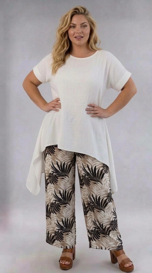 Παντελόνα γυναικεία εμπριμέ plus size - PANT201 | Candiashop Boutique, Η παντελόνα αυτή είναι η ιδανική επιλογή για κάθε γυναίκα που αναζητά άνεση και στυλ σε ένα μοναδικό κομμάτι. Διαθέτει εντυπωσιακό τροπικό μοτίβο με φύλλα φοίνικα σε βαθύ μαύρο χρώμα, που ξεχωρίζουν πάνω σε μπεζ-γκρίζο φόντο, δημιουργώντας ένα δυναμικό και μοντέρνο αποτέλεσμα. Η φαρδιά γραμμή palazzo προσφέρει εξαιρετική άνεση κίνησης, ενώ η ψηλόμεση εφαρμογή κολακεύει τη σιλουέτα και αναδεικνύει τις καμπύλες με χάρη. Το ελαφρύ ύφασμα την καθιστά ιδανική για ζεστές μέρες, ενώ το boho-chic ύφος της ταιριάζει τέλεια με διάφορα looks. Μπορεί να φορεθεί με λευκό oversized top, όπως φαίνεται στη φωτογραφία, αλλά και με ένα απλό μονόχρωμο αμάνικο ή ένα κομψό σατέν πουκάμισο. Κατάλληλη για καθημερινές εξόδους, βόλτες στην παραλία, αλλά και για πιο χαλαρές επαγγελματικές περιστάσεις. Ένα must-have κομμάτι για κάθε plus size γκαρνταρόμπα!