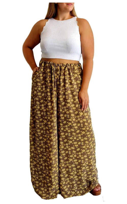 Ανακαλύψτε την απόλυτη άνεση και κομψότητα με αυτή την εντυπωσιακή παντελόνα σε πλούσιο καφέ\u002Dχρυσαφί χρώμα με διακριτικό φλοράλ μοτίβο. Κατασκευασμένη από ελαφρύ, ρέον ύφασμα που χαρίζει άνετη εφαρμογή και ελευθερία κινήσεων, είναι ιδανική για τις ζεστές καλοκαιρινές ημέρες. Η φαρδιά γραμμή της με την ελαστική μέση προσφέρει εξαιρετική άνεση, ενώ οι πρακτικές πλαϊνές τσέπες προσθέτουν λειτουργικότητα στο κομμάτι. Συνδυάστε την με το λευκό ριμπ τοπ που απεικονίζεται ή με οποιοδήποτε μονόχρωμο τοπ για καθημερινές εμφανίσεις. Ιδανική για παραλιακούς περιπάτους, καλοκαιρινές διακοπές ή χαλαρά απογευματινά ραντεβού. Η παντελόνα διαθέτει μεγάλο μήκος που την καθιστά κατάλληλη για διαφορετικούς σωματότυπους, ενώ το διαχρονικό της σχέδιο εξασφαλίζει ότι θα παραμείνει στη ντουλάπα σας για πολλές σεζόν. Η άνετη εφαρμογή της την καθιστά ιδανική επιλογή για γυναίκες που αναζητούν στυλ χωρίς να θυσιάζουν την άνεση.