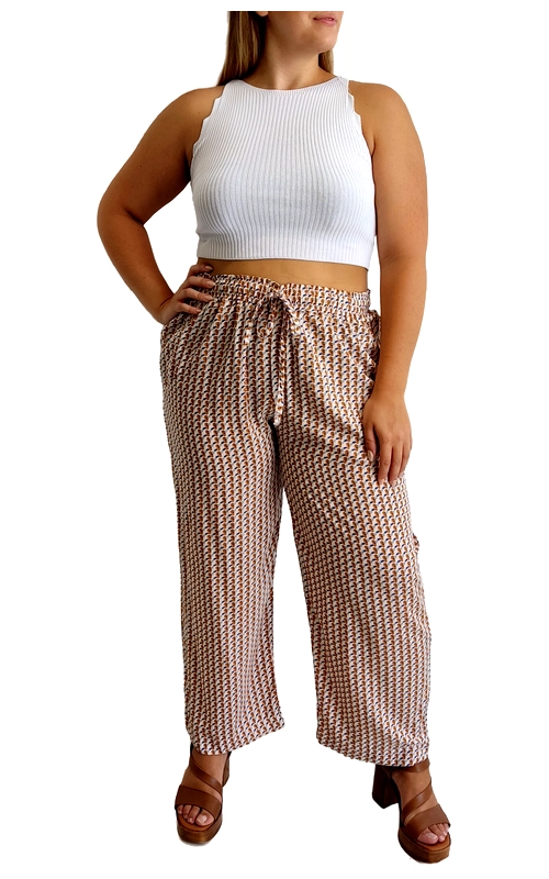 Αυτή η κομψή φαρδιά παντελόνα με γεωμετρικό μοτίβο σε αποχρώσεις του καφέ, μπεζ και λευκού αποτελεί την ιδανική επιλογή για το καλοκαιρινό σας ντύλιμο. Κατασκευασμένη από ελαφρύ, αέρινο ύφασμα που επιτρέπει στο δέρμα να αναπνέει, προσφέρει άνεση και στυλ ακόμα και τις πιο ζεστές ημέρες. Η ψηλόμεση γραμμή με το κορδόνι στη μέση επιτρέπει την προσαρμογή στις διαστάσεις σας, ενώ το φαρδύ πόδι χαρίζει ελευθερία κινήσεων και κολακεύει κάθε σωματότυπο. Συνδυάζεται υπέροχα με το λευκό πλεκτό τοπ όπως απεικονίζεται, αλλά και με μονόχρωμα μπλουζάκια ή πουκάμισα για διαφορετικές περιστάσεις. Ιδανική για καλοκαιρινές βόλτες, παραλιακούς περιπάτους ή ακόμα και για casual επαγγελματικές εμφανίσεις. Οι καφέ δερμάτινες πλατφόρμες συμπληρώνουν τέλεια το σύνολο. Το γεωμετρικό μοτίβο προσθέτει ενδιαφέρον στην εμφάνισή σας, ενώ οι γήινες αποχρώσεις ταιριάζουν εύκολα με πολλά χρώματα από την υπάρχουσα γκαρνταρόμπα σας.
