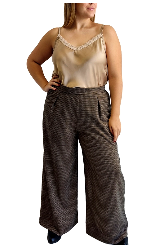 Κομψή και μοντέρνα, αυτή η γυναικεία παντελόνα με φαρδιά γραμμή αποτελεί μια εξαιρετική επιλογή για το καθημερινό σας στυλ. Το καφέ καρό μοτίβο σε διακριτικούς τόνους προσδίδει κομψότητα και διαχρονικότητα στο ένδυμα. Συνδυάζεται άψογα με το μπεζ σατέν τοπ με λεπτές τιράντες και διακοσμητική δαντέλα στο ντεκολτέ, δημιουργώντας μια ισορροπημένη σιλουέτα. Η παντελόνα διαθέτει ψηλή μέση με κομψές πιέτες που κολακεύουν τη σιλουέτα, ενώ το φαρδύ πόδι χαρίζει άνεση και στυλ. Το υφασμάτινο καρό σχέδιο προσφέρει ευελιξία στους συνδυασμούς, καθιστώντας την ιδανική επιλογή τόσο για το γραφείο όσο και για απογευματινές εξόδους. Μπορεί να φορεθεί με μποτάκια για ένα κομψό χειμερινό look ή με γόβες για πιο επίσημες περιστάσεις. Συνδυάστε την με ένα ζεστό πουλόβερ για τις κρύες μέρες ή με το συνοδευτικό σατέν τοπ για μια πιο κομψή εμφάνιση. Η άνετη εφαρμογή και το ποιοτικό ύφασμα εγγυώνται άνεση καθ\u0027 όλη τη διάρκεια της ημέρας.