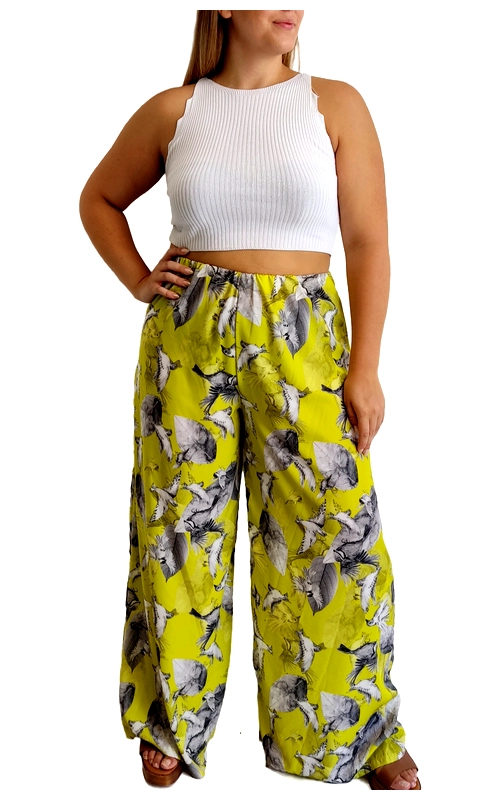 Αυτή η εντυπωσιακή παντελόνα σε φαρδιά γραμμή αποτελεί την τέλεια επιλογή για το καλοκαιρινό σας γκαρνταρόμπα. Σε ζωηρό κίτρινο\u002Dλαχανί φόντο με αφηρημένα μοτίβα σε αποχρώσεις του γκρι και λευκού, δημιουργεί μια εντυπωσιακή αντίθεση που τραβάει τα βλέμματα. Η χαλαρή, άνετη εφαρμογή της με το ελαστικό λάστιχο στη μέση προσφέρει εξαιρετική άνεση, ενώ το φαρδύ πλάτος στα πόδια χαρίζει κομψότητα και δροσιά τις ζεστές ημέρες. Ιδανική για καλοκαιρινές εξορμήσεις, από απογευματινούς περιπάτους στην παραλία μέχρι κοκτέιλ πάρτι στην πόλη. Συνδυάζεται τέλεια με απλά μονόχρωμα τοπ, όπως το λευκό πλεκτό crop top της φωτογραφίας, αλλά και με μαύρα ή γκρι μπλουζάκια για πιο διακριτικές εμφανίσεις. Το ελαφρύ, αέρινο ύφασμα επιτρέπει την άνετη κίνηση, ενώ η εντυπωσιακή χρωματική παλέτα αναδεικνύει την προσωπικότητα και το στυλ σας. Ολοκληρώστε το σύνολο με πλατφόρμες ή σανδάλια για μια κομψή καλοκαιρινή εμφάνιση.