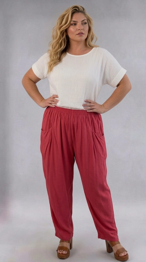 Παντελόνα γυναικεία κοραλλί plus size - PANT205 | Candiashop Boutique, Η παντελόνα αυτή σε πλούσια απόχρωση σκουριάς αποτελεί την ιδανική επιλογή για τη σύγχρονη γυναίκα plus size που αναζητά στυλ και άνεση σε ένα. Η χαλαρή, ευρύχωρη γραμμή της εξασφαλίζει απόλυτη ελευθερία κινήσεων, ενώ η ελαστική μέση προσφέρει τέλεια εφαρμογή και υποστήριξη καθ' όλη τη διάρκεια της ημέρας. Το ελαφρύ, ρέον ύφασμα πέφτει κομψά στο σώμα, δημιουργώντας μια αισθητικά αρμονική σιλουέτα. Διαθέτει δύο πλαϊνές τσέπες, συνδυάζοντας πρακτικότητα και στυλ, ενώ το μονόχρωμο σχέδιο της προσφέρει ευελιξία στον συνδυασμό της με διάφορα ρούχα. Μπορεί να φορεθεί με λευκή μπλούζα για ένα casual καθημερινό look, αλλά και με κομψό σατέν τοπ για βραδινές εξόδους. Ιδανική για καλοκαιρινές βόλτες, ταξίδια ή χαλαρές συναντήσεις με φίλους, η παντελόνα αυτή αποτελεί must-have κομμάτι για κάθε γυναικεία γκαρνταρόμπα που εκτιμά τον συνδυασμό άνεσης και μοντέρνας αισθητικής.