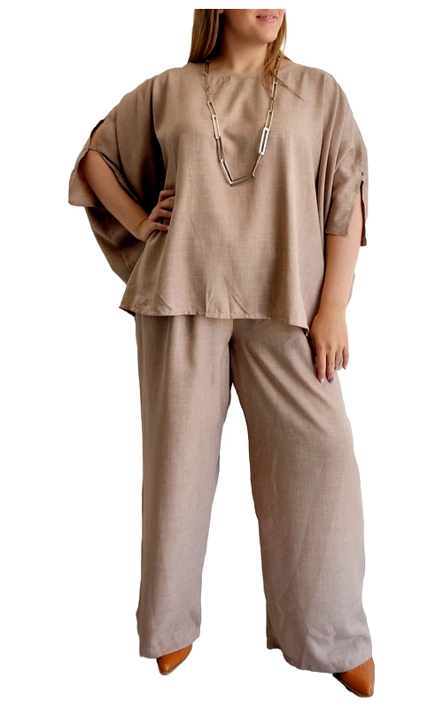 Κομψό σετ σε απαλή μπεζ απόχρωση, ιδανικό για την καθημερινή σας γκαρνταρόμπα. Το σύνολο περιλαμβάνει μια φαρδιά μπλούζα με χαλαρή γραμμή και φαρδιά μανίκια που διπλώνουν χαριτωμένα, προσφέροντας άνεση και στυλ. Συνδυάζεται με μια φαρδιά παντελόνα στην ίδια μπεζ απόχρωση, δημιουργώντας ένα αρμονικό σύνολο που κολακεύει κάθε σωματότυπο. Το υλικό έχει μια ελαφρώς υφασμάτινη όψη που προσδίδει κομψότητα, ενώ παράλληλα εξασφαλίζει άνεση για όλη την ημέρα. Η μινιμαλιστική σχεδίαση επιτρέπει αμέτρητους συνδυασμούς με αξεσουάρ, όπως το εντυπωσιακό κολιέ που φαίνεται στη φωτογραφία. Φορέστε το σετ με μυτερές γόβες για επαγγελματικές συναντήσεις ή καθημερινές εξόδους. Η χαλαρή γραμμή και το αέρινο ύφασμα το καθιστούν ιδανική επιλογή για τις ζεστές μέρες, προσφέροντας παράλληλα κομψότητα και στυλ. Ένα διαχρονικό σύνολο που συνδυάζει την άνεση με την κομψότητα και μπορεί να αποτελέσει βασικό κομμάτι της καλοκαιρινής σας γκαρνταρόμπας.