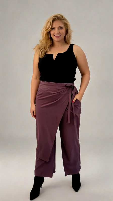Παντελόνα γυναικεία plus size ανοιξιάτικη λιλά - PANT166 | Candiashop Boutique, Κομψή παντελόνα σε υπέροχη απόχρωση μελιτζανί, ιδανική για κάθε περίσταση από το γραφείο μέχρι το βραδινό δείπνο. Διαθέτει μοναδικό σχεδιασμό με εντυπωσιακό κρουαζέ μπροστινό μέρος που δένει στο πλάι με κορδόνι, προσφέροντας άνεση και προσαρμοσμένη εφαρμογή στη μέση. Η φαρδιά γραμμή της χαρίζει κίνηση και θηλυκότητα, ενώ οι λειτουργικές τσέπες προσθέτουν πρακτικότητα στο κομμάτι. Συνδυάζεται τέλεια με ένα μαύρο αμάνικο τοπ με ιδιαίτερο ντεκολτέ όπως αυτό της φωτογραφίας, δημιουργώντας μια εκλεπτυσμένη εμφάνιση. Η ρευστή υφή του υφάσματος χαρίζει άνεση στην κίνηση και κολακεύει κάθε σωματότυπο. Φορέστε την με μαύρα μυτερά μποτάκια για ένα δυναμικό look ή με κομψά πέδιλα για πιο επίσημες περιστάσεις. Αυτή η παντελόνα αποτελεί ένα ευέλικτο κομμάτι που θα αναβαθμίσει άμεσα τη γκαρνταρόμπα σας και θα σας συνοδεύει σε πολλές περιστάσεις.