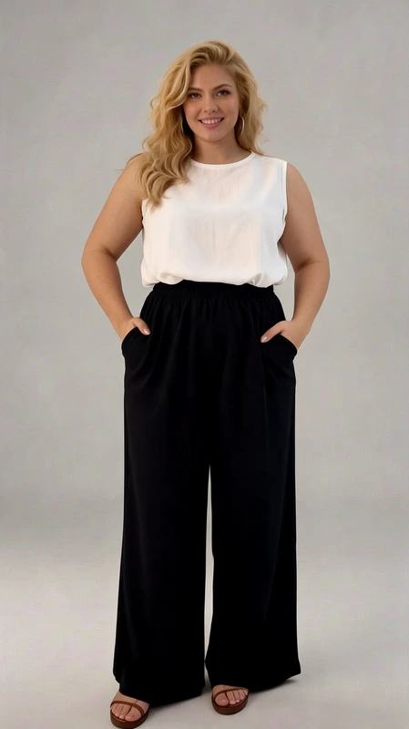 Παντελόνα γυναικεία μαύρη καλοκαιρινή plus size - PANT178 | Candiashop Boutique, Κομψή και άνετη παντελόνα σε βαθύ μπλε σκούρο (μαύρο-μπλε) χρώμα, συνδυασμένη με ένα αέρινο λευκό αμάνικο τοπ. Η φαρδιά γραμμή της παντελόνας χαρίζει απόλυτη άνεση και κίνηση, ενώ η ψηλή μέση κολακεύει τη σιλουέτα και αναδεικνύει τη μέση. Διαθέτει πρακτικές πλαϊνές τσέπες που προσθέτουν λειτουργικότητα στο κομμάτι. Το ρευστό ύφασμα πέφτει απαλά και δημιουργεί ένα κομψό παιχνίδισμα με κάθε κίνηση. Ιδανική επιλογή για το γραφείο, επαγγελματικές συναντήσεις αλλά και απογευματινές εξόδους. Συνδυάστε την με γόβες για ένα επίσημο look ή με flat σανδάλια για πιο casual εμφανίσεις. Μπορεί εύκολα να μεταμορφωθεί από πρωινό σε βραδινό outfit αλλάζοντας απλά τα αξεσουάρ. Η άνετη ελαστική μέση προσφέρει εξαιρετική εφαρμογή σε διαφορετικούς σωματότυπους, ενώ το μήκος της είναι ιδανικό για όλα τα αναστήματα.