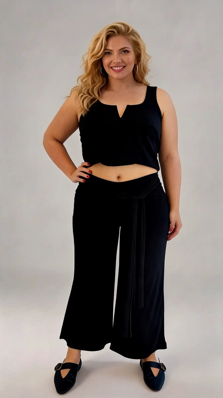 Κομψό σετ crop top και παντελόνα σε βαθύ μπλε χρώμα, ιδανικό για καλοκαιρινές εμφανίσεις με στυλ και άνεση. Το μπλουζάκι διαθέτει ιδιαίτερο σχεδιασμό με λαιμόκοψη V και φαρδιές τιράντες που προσφέρουν άνετη εφαρμογή, ενώ το κοντό μήκος του αναδεικνύει τη σιλουέτα με θηλυκότητα. Η φαρδιά παντελόνα σε γραμμή palazzo συνδυάζει την κομψότητα με την πρακτικότητα, χάρη στη ζώνη από το ίδιο ύφασμα που τονίζει τη μέση. Το μαλακό, ρέον ύφασμα χαρίζει ελευθερία κινήσεων και δροσερή αίσθηση, ενώ η μήκος στον αστράγαλο δημιουργεί μια κολακευτική σιλουέτα. Ιδανικό για καλοκαιρινές βραδινές εξόδους, παραλιακούς περιπάτους ή ακόμα και για πιο επίσημες περιστάσεις όταν συνδυαστεί με τα κατάλληλα αξεσουάρ. Φορέστε το με πέδιλα ή μπαλαρίνες για μια ολοκληρωμένη εμφάνιση που συνδυάζει κομψότητα και άνεση.