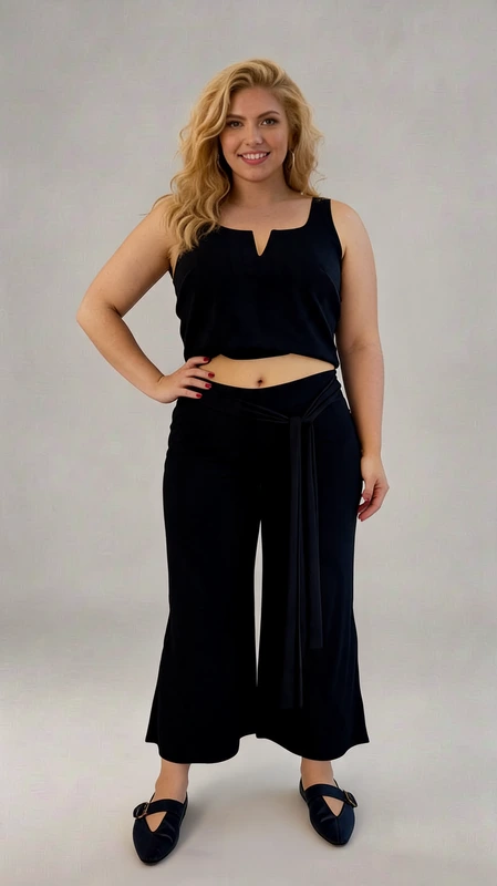 Παντελόνα γυναικεία plus size ανοιξιάτικη μαύρη - PANT169 | Candiashop Boutique, Κομψό σετ crop top και παντελόνα σε βαθύ μπλε χρώμα, ιδανικό για καλοκαιρινές εμφανίσεις με στυλ και άνεση. Το μπλουζάκι διαθέτει ιδιαίτερο σχεδιασμό με λαιμόκοψη V και φαρδιές τιράντες που προσφέρουν άνετη εφαρμογή, ενώ το κοντό μήκος του αναδεικνύει τη σιλουέτα με θηλυκότητα. Η φαρδιά παντελόνα σε γραμμή palazzo συνδυάζει την κομψότητα με την πρακτικότητα, χάρη στη ζώνη από το ίδιο ύφασμα που τονίζει τη μέση. Το μαλακό, ρέον ύφασμα χαρίζει ελευθερία κινήσεων και δροσερή αίσθηση, ενώ η μήκος στον αστράγαλο δημιουργεί μια κολακευτική σιλουέτα. Ιδανικό για καλοκαιρινές βραδινές εξόδους, παραλιακούς περιπάτους ή ακόμα και για πιο επίσημες περιστάσεις όταν συνδυαστεί με τα κατάλληλα αξεσουάρ. Φορέστε το με πέδιλα ή μπαλαρίνες για μια ολοκληρωμένη εμφάνιση που συνδυάζει κομψότητα και άνεση.