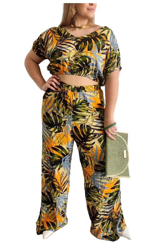 Εντυπωσιακό σετ δύο τεμαχίων με τροπικό μοτίβο που θα αναβαθμίσει το καλοκαιρινό σας στυλ. Το σύνολο αποτελείται από ένα κοντό τοπ με φαρδιά μανίκια και μια φαρδιά παντελόνα ψηλόμεση, διακοσμημένα με ζωηρό σχέδιο τροπικών φύλλων σε αποχρώσεις πορτοκαλί ώχρας, λαδί πράσινου και γαλαζωπού σε κρεμ φόντο. Η χαλαρή γραμμή του συνόλου προσφέρει άνεση και κολακεύει κάθε σωματότυπο, ενώ το crop top με το V λαιμόκοψη χαρίζει θηλυκότητα στην εμφάνιση. Η παντελόνα με το φαρδύ πόδι εξασφαλίζει ελευθερία κινήσεων και στυλ. Ιδανικό για καλοκαιρινές εξορμήσεις, διακοπές σε νησί ή απογευματινά κοκτέιλ στην παραλία. Συνδυάστε το με χρυσά αξεσουάρ και πλατφόρμες για βραδινές εμφανίσεις ή με επίπεδα σανδάλια για πιο χαλαρές περιστάσεις. Το λεπτό ύφασμα είναι ιδανικό για τις ζεστές μέρες, προσφέροντας δροσιά και στυλ σε μία εντυπωσιακή εμφάνιση.