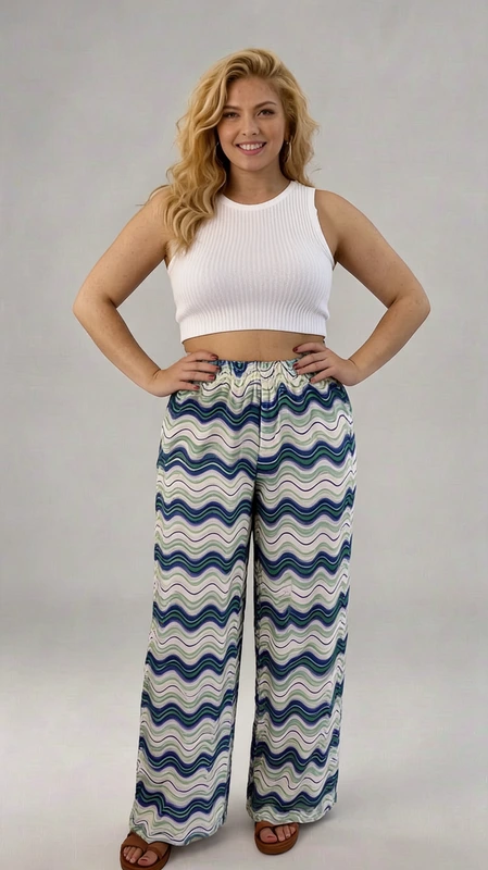 Παντελόνα γυναικεία plus size καλοκαιρινή μπλε - PANT150 | Candiashop Boutique, Κομψή και άνετη, αυτή η φαρδιά παντελόνα με το εντυπωσιακό κυματιστό μοτίβο θα αναβαθμίσει άμεσα το καλοκαιρινό σας στυλ. Η παλέτα χρωμάτων συνδυάζει αρμονικά αποχρώσεις του γαλάζιου, μπλε, λευκού και πράσινου σε κομψούς κυματισμούς που θυμίζουν θάλασσα. Η ελαστική μέση προσφέρει άνεση και προσαρμόζεται εύκολα σε διαφορετικούς σωματότυπους, ενώ το φαρδύ πλάτος του ποδιού χαρίζει ελευθερία κινήσεων και δροσιά τις ζεστές ημέρες. Ιδανική για παραλιακές εξορμήσεις, απογευματινούς περιπάτους ή χαλαρά γεύματα, αυτή η παντελόνα συνδυάζεται τέλεια με ένα λευκό crop top όπως απεικονίζεται, αλλά και με απλά μπλουζάκια ή μπουστάκια. Το ελαφρύ ύφασμα είναι ιδανικό για το καλοκαίρι, προσφέροντας άνεση χωρίς να ζεσταίνει. Το μοναδικό σχέδιο και η ρέουσα γραμμή της την καθιστούν ξεχωριστό κομμάτι για κάθε γυναικεία γκαρνταρόμπα που αναζητά στυλ με άνεση και προσωπικότητα.