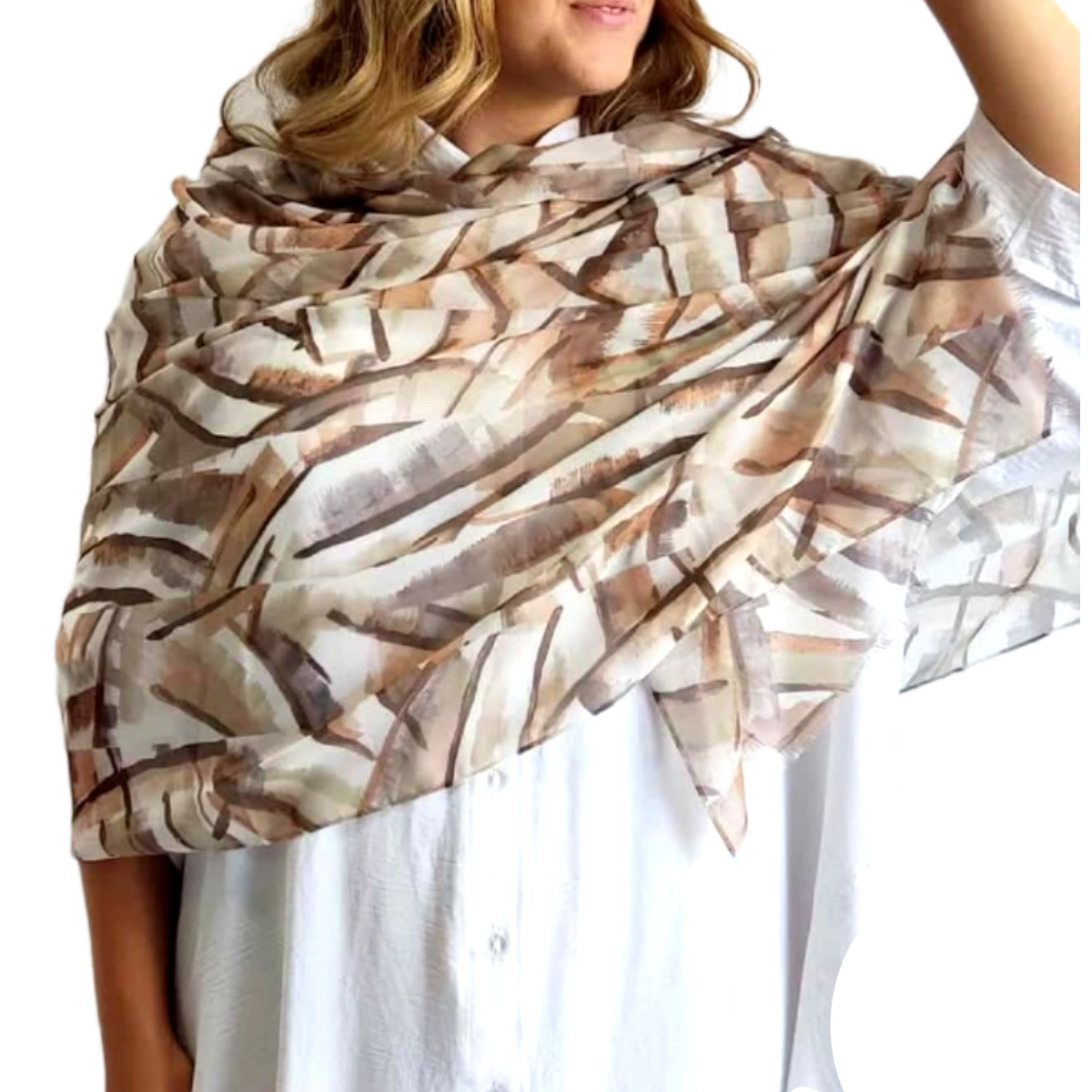 Αυτό το κομψό φουλάρι με τις απαλές γήινες αποχρώσεις αποτελεί την ιδανική προσθήκη στη γκαρνταρόμπα σας. Σε μια εντυπωσιακή παλέτα χρωμάτων που συνδυάζει εκρού, μπεζ, καφέ και ταμπά τόνους, το φουλάρι διαθέτει ένα μοντέρνο γεωμετρικό μοτίβο που θυμίζει αφηρημένη τέχνη. Το λεπτό, διάφανο ύφασμα πέφτει απαλά γύρω από τους ώμους, προσφέροντας έναν αέρινο όγκο που κολακεύει κάθε σιλουέτα. Ιδανικό για όλες τις εποχές, μπορεί να φορεθεί με αμέτρητους τρόπους \u002D τυλιγμένο χαλαρά γύρω από το λαιμό, ριγμένο στους ώμους σαν εσάρπα ή ακόμα και ως κομψό αξεσουάρ για τα μαλλιά. Συνδυάζεται τέλεια με λευκά ή μονόχρωμα ρούχα, όπως φαίνεται στην εικόνα με το λευκό πουκάμισο, αλλά και με καθημερινά τζιν ή επίσημα σύνολα. Η ελαφριά υφή του το καθιστά εύκολο στη μεταφορά, ενώ το διαχρονικό του σχέδιο εγγυάται πως θα παραμείνει στη μόδα για πολλές σεζόν. Ένα πολυτελές αξεσουάρ που προσθέτει κομψότητα σε κάθε εμφάνιση.