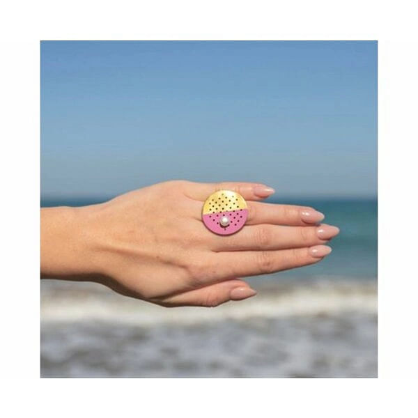 Μεγάλο statement δαχτυλίδι με μαργαριτάρι και χρώμα - 12184, Ένα εντυπωσιακό statement δαχτυλίδι που συνδυάζει την κλασική κομψότητα με το μοντέρνο design. Το μοναδικό αυτό χειροποίητο κόσμημα, σχεδιασμένο από την Ελληνίδα Σχεδιάστρια Κοσμημάτων Αικατερίνη Χαλκιαδάκη, αποτελεί την τέλεια επιλογή για τη γυναίκα που επιθυμεί να ξεχωρίσει.
Η γεωμετρική κυκλική βάση από ορείχαλκο παρουσιάζει έναν εξαιρετικό συνδυασμό χρωμάτων - χρυσαφί και φούξια ροζ - που δημιουργούν μια σύγχρονη αισθητική yin-yang. Η διάτρητη επιφάνεια με τις γεωμετρικές οπές προσδίδει έναν βιομηχανικό χαρακτήρα, ενώ το λευκό μαργαριτάρι στο κέντρο προσθέτει μια νότα κομψότητας και θηλυκότητας.
Το μεγάλο μέγεθος του δαχτυλιδιού το καθιστά ιδανικό για ιδιαίτερες εμφανίσεις και βραδινές εξόδους. Συνδυάζεται υπέροχα με μονόχρωμα outfits και προσθέτει χρώμα και στυλ σε κάθε look.