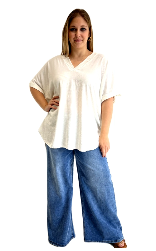 Η κοντομάνικη μπλούζα σε κρεμ λευκό χρώμα είναι η ιδανική επιλογή για κάθε γυναίκα που αναζητά άνεση χωρίς να θυσιάζει το στυλ της. Με τον κλασικό λαιμόκοψη σε σχήμα V και τη χαλαρή, oversized εφαρμογή της, χαρίζει μια αέρινη και ελεύθερη αίσθηση που κολακεύει κάθε σωματότυπο. Τα κοντά μανίκια με διπλωμένο τελείωμα προσθέτουν έναν κομψό και καθημερινό χαρακτήρα, ενώ το στρογγυλεμένο τελείωμα στο κάτω μέρος δημιουργεί μια γραμμή που επιμηκύνει οπτικά τη σιλουέτα. Το απλό, μονόχρωμο σχέδιο της την κάνει εξαιρετικά ευέλικτη και εύκολη στο συνδυασμό. Μπορεί να φορεθεί με φαρδιά τζιν παντελόνια σε γαλάζιο χρώμα, όπως φαίνεται στη φωτογραφία, δημιουργώντας ένα τέλειο casual σύνολο. Εξίσου ταιριαστή είναι με leggings, φούστες ή σορτς για μια ανάλαφρη καλοκαιρινή εμφάνιση. Ιδανική για καθημερινές εξόδους, αγορές ή χαλαρές συναντήσεις με φίλους, αυτή η μπλούζα είναι ένα must\u002Dhave κομμάτι για κάθε plus size γκαρνταρόμπα.