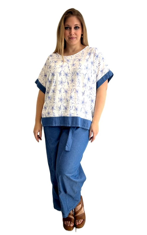 Ανακαλύψτε αυτή την υπέροχη κοντομάνικη μπλούζα που συνδυάζει στυλ και άνεση για τη σύγχρονη γυναίκα. Σε λευκό φόντο με μπλε ρουά floral μοτίβο, η μπλούζα αναδεικνύει μια φρέσκια, καλοκαιρινή αισθητική που ταιριάζει σε κάθε περίσταση. Το ιδιαίτερο σχέδιό της με τα繊細α λουλούδια δίνει έναν ρομαντικό χαρακτήρα, ενώ η μπλε ντένιμ λεπτομέρεια στα μανίκια και στο κάτω μέρος της μπλούζας προσθέτει μια μοντέρνα πινελιά. Η ευρύχωρη, oversized γραμμή της εξασφαλίζει τέλεια εφαρμογή και ελευθερία κινήσεων, ιδανική για plus size σιλουέτες. Ο στρογγυλός λαιμός και τα κοντά μανίκια με διπλωμένο τελείωμα την κάνουν ιδιαίτερα κομψή. Μπορεί να φορεθεί με τζιν παντελόνι σε γαλάζιο χρώμα, όπως στην εικόνα, για ένα αρμονικό σύνολο, αλλά και με λευκό ή μπεζ παντελόνι για πιο casual εμφάνιση. Κατάλληλη για καθημερινές εξόδους, βόλτες και καλοκαιρινές συγκεντρώσεις.