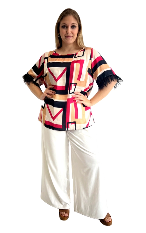 Μια εντυπωσιακή κοντομάνικη μπλούζα που συνδυάζει στυλ και γοητεία για τη σύγχρονη plus size γυναίκα. Το τολμηρό γεωμετρικό μοτίβο της, σε αποχρώσεις εκρού, φούξια, σκούρο μπλε και μπεζ\u002Dπορτοκαλί, δημιουργεί ένα δυναμικό αποτέλεσμα που τραβά αμέσως την προσοχή. Το ευρύχωρο, relaxed fit της χαρίζει άνεση και ελευθερία κινήσεων, ενώ η στρογγυλή λαιμόκοψη προσθέτει κομψότητα. Το πιο ξεχωριστό στοιχείο της είναι τα φτερά στα μανίκια, σε σκούρο χρώμα, που της δίνουν έναν glamorous και φεστιβαλικό χαρακτήρα. Μπορεί να φορεθεί με λευκό παντελόνι καμπάνα για ένα chic ολοκληρωμένο look, όπως φαίνεται στη φωτογραφία, αλλά και με τζιν ή φούστα για πιο casual εμφανίσεις. Ιδανική για βραδινές έξοδοι, καλοκαιρινές εκδηλώσεις, γάμους ή ακόμα και για ένα κομψό καλοκαιρινό πάρτι. Μια μπλούζα που θα κάνει κάθε εμφάνισή σας αξέχαστη!