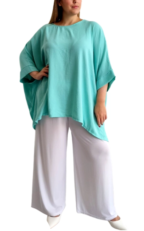 Αυτή η εντυπωσιακή μπλούζα σε απαλό τιρκουάζ χρώμα αποτελεί την ιδανική επιλογή για το καλοκαιρινό σας γκαρνταρόμπα. Με φαρδιά, άνετη γραμμή τύπου πόντσο και φαρδιά μανίκια 3/4, προσφέρει μια κολακευτική εφαρμογή που αγκαλιάζει το σώμα με κομψότητα. Το ελαφρύ, αέρινο ύφασμα επιτρέπει την κυκλοφορία του αέρα, καθιστώντας την ιδανική για τις ζεστές μέρες. Ο ασύμμετρος σχεδιασμός με το μεγαλύτερο μήκος στα πλαϊνά προσθέτει μια μοντέρνα πινελιά, ενώ η απλή στρογγυλή λαιμόκοψη προσφέρει διαχρονική κομψότητα. Συνδυάζεται τέλεια με λευκές φαρδιές παντελόνες όπως στην εικόνα, αλλά και με τζιν, σορτς ή φούστες για πολλαπλές περιστάσεις. Ιδανική για καθημερινές εμφανίσεις, βόλτες στην παραλία ή ακόμα και για βραδινές εξόδους με τα κατάλληλα αξεσουάρ. Το συγκεκριμένο κομμάτι διαθέτει χαλαρή εφαρμογή που κολακεύει όλους τους σωματότυπους και προσφέρει άνεση και στυλ σε κάθε περίσταση.