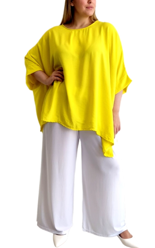 Αυτή η εντυπωσιακή μπλούζα σε λαμπερό κίτρινο χρώμα αποτελεί την τέλεια επιλογή για να φωτίσετε την καλοκαιρινή σας γκαρνταρόμπα. Με την άνετη, φαρδιά γραμμή τύπου poncho και τα φαρδιά μανίκια, προσφέρει μια κολακευτική εφαρμογή που ταιριάζει σε κάθε σωματότυπο. Το ελαφρύ, ρέον ύφασμα χαρίζει άνεση και δροσιά κατά τις ζεστές ημέρες, ενώ η ασύμμετρη γραμμή στο τελείωμα προσθέτει μια μοντέρνα πινελιά στο σύνολο. Ο απλός, μινιμαλιστικός σχεδιασμός με τη στρογγυλή λαιμόκοψη την καθιστά εύκολη στο συνδυασμό, όπως φαίνεται στην εικόνα με τις λευκές φαρδιές παντελόνες. Ιδανική για καθημερινές εμφανίσεις, βόλτες στην πόλη ή ακόμα και για χαλαρές επαγγελματικές συναντήσεις όταν συνδυάζεται με τα κατάλληλα αξεσουάρ. Το ζωηρό κίτρινο χρώμα αναδεικνύει τη μαυρισμένη επιδερμίδα και προσθέτει ζωντάνια σε κάθε εμφάνιση. Συνδυάστε την με λευκά, μπεζ ή τζιν παντελόνια για ένα ολοκληρωμένο καλοκαιρινό σύνολο που θα τραβήξει όλα τα βλέμματα.