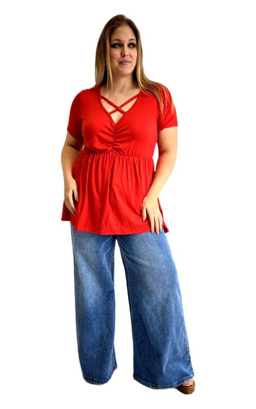 Η κοντομάνικη μπλούζα αυτή σε έντονο κόκκινο χρώμα αποτελεί μια τολμηρή και θηλυκή επιλογή για κάθε γυναίκα που αγαπά το στυλ και την άνεση. Το πιο εντυπωσιακό χαρακτηριστικό της είναι το σταυρωτό διακοσμητικό λουράκι στο ντεκολτέ, που δημιουργεί έναν αισθησιακό και μοντέρνο σχεδιασμό, ενώ η λαιμόκοψη τύπου V προσθέτει κομψότητα. Το μπούστο διαθέτει λεπτό σούρωμα στο κέντρο, που τονίζει τη σιλουέτα, και η φαρδιά, ρομαντική φούστα babydoll χαρίζει άνεση και χάρη. Η εφαρμογή είναι ιδανική για plus size σώματα, καθώς ο σχεδιασμός αναδεικνύει τις καμπύλες με τον πιο κολακευτικό τρόπο. Κατασκευασμένη από μαλακό, ελαστικό ύφασμα, εξασφαλίζει άνεση καθ\u0027 όλη τη διάρκεια της ημέρας. Μπορεί να φορεθεί με φαρδύ τζιν παντελόνι, όπως στη φωτογραφία, αλλά και με στενό παντελόνι ή φούστα. Ιδανική για καθημερινές εξόδους, βόλτες και καλοκαιρινές συναντήσεις με φίλες.