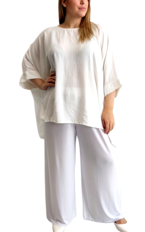 Αυτή η κομψή φαρδιά μπλούζα σε λευκό εκρού χρώμα αποτελεί την τέλεια προσθήκη στη γκαρνταρόμπα κάθε γυναίκας που αναζητά άνεση και στυλ. Με τον χαλαρό, oversized σχεδιασμό της και τα φαρδιά μανίκια τύπου kimono που φτάνουν στους αγκώνες, προσφέρει μια αέρινη αίσθηση ιδανική για τις ζεστές μέρες. Το απαλό ύφασμα αγκαλιάζει το σώμα με χάρη, ενώ η στρογγυλή λαιμόκοψη προσδίδει μια διαχρονική κομψότητα. Συνδυάζεται τέλεια με τις φαρδιές παντελόνες σε ανοιχτό γκρι που φαίνονται στην εικόνα, αλλά είναι εξίσου εντυπωσιακή με τζιν, κολάν ή φούστες. Η ασύμμετρη γραμμή στο τελείωμά της προσθέτει μια μοντέρνα πινελιά, ενώ η απλότητα του σχεδίου την καθιστά ευέλικτο κομμάτι για καθημερινές εμφανίσεις ή πιο επίσημες περιστάσεις. Φορέστε την στο γραφείο, σε μια βόλτα για καφέ ή ακόμα και σε καλοκαιρινές βραδινές εξόδους, συνδυάζοντάς την με τα κατάλληλα αξεσουάρ για να μεταμορφώσετε το look σας ανάλογα με την περίσταση.