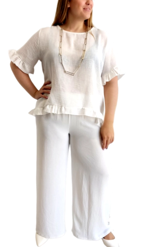 Αυτό το κομψό σετ σε λευκό χρώμα αποτελεί την ιδανική επιλογή για τις καλοκαιρινές σας εμφανίσεις. Η μπλούζα είναι κατασκευασμένη από ελαφρύ, αέρινο ύφασμα με υφή λινού που χαρίζει άνεση και δροσιά τις ζεστές ημέρες. Διαθέτει χαλαρή γραμμή, στρογγυλή λαιμόκοψη και κοντά μανίκια με χαριτωμένα βολάν που προσθέτουν θηλυκότητα. Το κάτω μέρος της μπλούζας ολοκληρώνεται επίσης με διακριτικό βολάν που δημιουργεί μια κολακευτική σιλουέτα. Συνδυάζεται με φαρδύ παντελόνι στο ίδιο λευκό χρώμα, δημιουργώντας ένα αρμονικό σύνολο που μπορεί να φορεθεί από το πρωί μέχρι το βράδυ. Το παντελόνι έχει άνετη γραμμή και ελαστική μέση, προσφέροντας μέγιστη άνεση. Ιδανικό για καλοκαιρινές βόλτες, για το γραφείο με τα κατάλληλα αξεσουάρ, όπως το εντυπωσιακό κολιέ που φαίνεται στη φωτογραφία, ή για απογευματινούς καφέδες. Φορέστε το με λευκά sneakers για casual εμφανίσεις ή με πέδιλα για πιο επίσημες περιστάσεις.