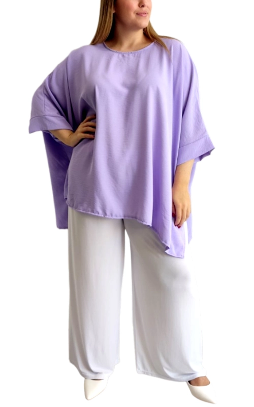 Αυτή η εντυπωσιακή μπλούζα σε απαλό λιλά χρώμα συνδυάζει άνεση και κομψότητα με τον ιδιαίτερο φαρδύ σχεδιασμό της. Διαθέτει χαλαρή γραμμή τύπου oversized που χαρίζει άνετη εφαρμογή και αέρινη αίσθηση, ενώ τα φαρδιά μανίκια με τις χαρακτηριστικές αναδιπλώσεις προσφέρουν μια πινελιά κομψότητας. Η ασύμμετρη γραμμή στο τελείωμα της μπλούζας δημιουργεί ένα μοντέρνο εφέ που κολακεύει κάθε σωματότυπο. Φορέστε την με λευκό παντελόνι όπως στην εικόνα για μια δροσερή καλοκαιρινή εμφάνιση ή συνδυάστε την με τζιν και αθλητικά παπούτσια για μια καθημερινή, άνετη επιλογή. Ιδανική για βόλτες στην πόλη, απογευματινούς καφέδες ή χαλαρές εξόδους. Το ελαφρύ ύφασμά της εξασφαλίζει άνεση καθ\u0027 όλη τη διάρκεια της ημέρας, ενώ το διαχρονικό της σχέδιο την καθιστά απαραίτητο κομμάτι για κάθε γυναικεία γκαρνταρόμπα. Η μπλούζα πλένεται εύκολα και διατηρεί το σχήμα και το χρώμα της ακόμα και μετά από πολλαπλές πλύσεις.