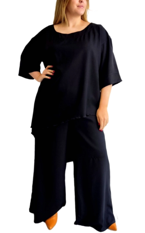 Αυτό το κομψό σετ σε βαθύ μαύρο χρώμα αποτελεί την ιδανική επιλογή για μια άνετη αλλά στυλάτη εμφάνιση. Η φαρδιά μπλούζα με τον χαλαρό σχεδιασμό διαθέτει στρογγυλή λαιμόκοψη και φαρδιά μανίκια τριών τετάρτων που προσφέρουν άνεση και αέρινη αίσθηση. Το ασύμμετρο τελείωμά της προσθέτει μια μοντέρνα πινελιά στο σύνολο. Συνδυάζεται με φαρδύ παντελόνι palazzo στην ίδια απόχρωση, δημιουργώντας ένα κομψό μονοχρωματικό σύνολο που κολακεύει κάθε σωματότυπο. Το μαλακό, ρέον ύφασμα χαρίζει άνεση καθ\u0027 όλη τη διάρκεια της ημέρας, ενώ η χαλαρή γραμμή του επιτρέπει ελευθερία κινήσεων. Ιδανικό για καθημερινές εξόδους, γραφείο με χαλαρό dress code ή απογευματινές συναντήσεις. Μπορεί να φορεθεί με χρωματιστά αξεσουάρ και παπούτσια, όπως τα ταμπά που εικονίζονται, για να δώσετε ζωντάνια στο σύνολο. Το σετ αυτό συνδυάζει τέλεια την κομψότητα με την άνεση, αποτελώντας βασικό κομμάτι για κάθε γυναικεία γκαρνταρόμπα.