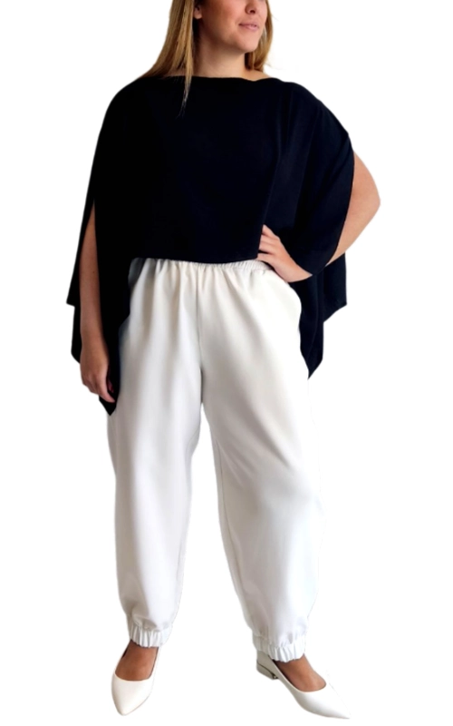 Αυτό το κομψό σύνολο αποτελείται από μια εντυπωσιακή μπλούζα τύπου πόντσο σε βαθύ ναυτικό μπλε χρώμα και ένα άνετο παντελόνι σε λευκό χρώμα. Η μπλούζα διαθέτει φαρδιά γραμμή με ασύμμετρο τελείωμα και ανοίγματα στα μανίκια που δημιουργούν μια αέρινη, κομψή εμφάνιση. Το χαλαρό στυλ της επιτρέπει άνετη εφαρμογή σε κάθε σωματότυπο, ενώ η μινιμαλιστική της αισθητική την καθιστά διαχρονική επιλογή. Το λευκό παντελόνι με το ελαστικό λάστιχο στη μέση και τους αστραγάλους προσφέρει εξαιρετική άνεση και προσαρμόζεται τέλεια στη σιλουέτα. Ο συνδυασμός του ναυτικού μπλε με το λευκό δημιουργεί μια κλασική, διαχρονική εμφάνιση που μπορεί να φορεθεί σε πολλές περιστάσεις, από καθημερινές βόλτες μέχρι απογευματινά γεύματα. Συνδυάστε το με λευκά παπούτσια για μια ολοκληρωμένη εμφάνιση ή με έντονα αξεσουάρ για πιο ιδιαίτερες περιστάσεις. Ιδανικό για τις ζεστές καλοκαιρινές ημέρες, προσφέροντας στυλ και άνεση σε κάθε σας κίνηση.