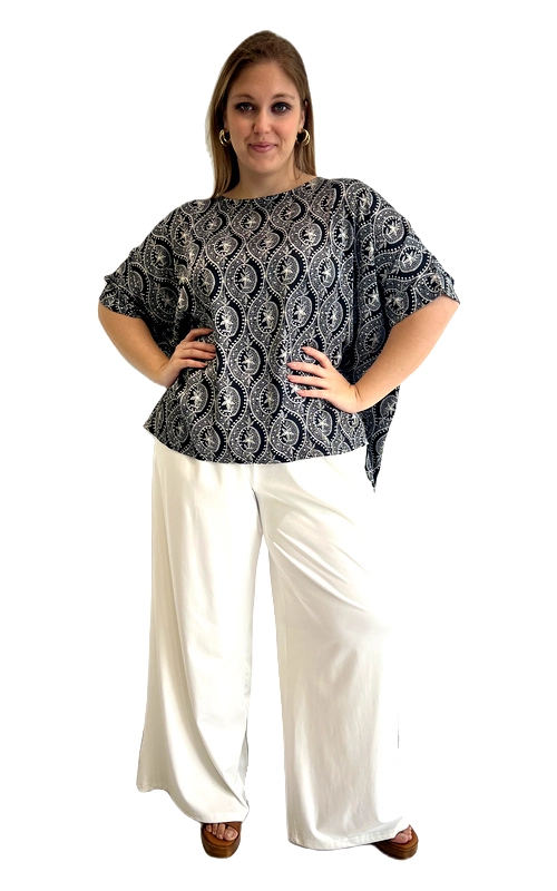 Ανακαλύψτε αυτή την εντυπωσιακή κοντομάνικη μπλούζα που συνδυάζει στυλ και άνεση για κάθε γυναίκα. Το βαθύ σκούρο μπλε χρώμα του υφάσματος διακοσμείται με ένα εξωτικό μοτίβο paisley σε λευκές και ασημί αποχρώσεις, δημιουργώντας ένα εντυπωσιακό οπτικό αποτέλεσμα. Η φαρδιά, oversized εφαρμογή της προσφέρει απόλυτη ελευθερία κινήσεων, ενώ ο στρογγυλός λαιμός και τα κοντά μανίκια με ελαφρά διακόσμηση την καθιστούν ιδανική για ζεστές μέρες. Η γραμμή της πέφτει χαλαρά στο σώμα, κολακεύοντας κάθε σιλουέτα, ιδανικά σχεδιασμένη για plus size γυναίκες που αναζητούν άνεση χωρίς να θυσιάζουν το στυλ τους. Μπορεί να φορεθεί με λευκό παντελόνι palazzo για ένα κομψό καλοκαιρινό σύνολο, όπως φαίνεται στη φωτογραφία, αλλά και με τζιν ή σορτς για πιο casual εμφανίσεις. Κατάλληλη για εξόδους, καφέ με φίλες ή ακόμα και για ημερήσιες εκδρομές, αυτή η μπλούζα αποτελεί must\u002Dhave κομμάτι της καλοκαιρινής σας γκαρνταρόμπας.