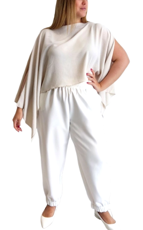 Αυτό το κομψό σύνολο σε λευκό ιβουάρ αποτελεί την τέλεια επιλογή για γυναίκες που αναζητούν άνεση και στυλ. Η ασύμμετρη μπλούζα με τον φαρδύ σχεδιασμό τύπου πόντσο διαθέτει χαλαρή εφαρμογή που κολακεύει κάθε σωματότυπο, ενώ η μία πλευρά της πέφτει χαριτωμένα δημιουργώντας ένα ιδιαίτερο στυλ. Συνδυάζεται με άνετο παντελόνι στην ίδια απόχρωση με λάστιχο στη μέση και στους αστραγάλους για μέγιστη άνεση. Το εκλεπτυσμένο λευκό χρώμα προσφέρει διαχρονική κομψότητα και ευελιξία στο συνδυασμό με άλλα ρούχα και αξεσουάρ. Το ύφασμα είναι ελαφρύ και ρέον, ιδανικό για καλοκαιρινές βραδιές ή επίσημες περιστάσεις. Φορέστε το σε καλοκαιρινά πάρτι, βραδινές εξόδους ή ακόμα και σε γάμους με τα κατάλληλα αξεσουάρ. Συνδυάστε το με ψηλοτάκουνα παπούτσια και εντυπωσιακά κοσμήματα για μια πιο επίσημη εμφάνιση ή με flat σανδάλια για πιο καθημερινές περιστάσεις. Η αέρινη εφαρμογή προσφέρει άνεση όλη μέρα, ενώ η μοντέρνα σχεδίαση εγγυάται στιλ και κομψότητα.