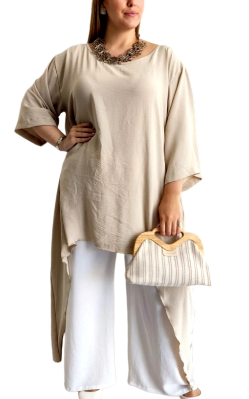 Αυτή η εντυπωσιακή ασύμμετρη μπλούζα σε απαλό εκρού χρώμα αποτελεί την τέλεια προσθήκη στη καλοκαιρινή σας γκαρνταρόμπα. Κατασκευασμένη από ελαφρύ, αέρινο ύφασμα που χαρίζει άνεση και δροσιά τις ζεστές ημέρες. Διαθέτει φαρδιά γραμμή με χαλαρή εφαρμογή και φαρδιά μανίκια τριών τετάρτων που προσφέρουν κομψή κάλυψη. Το πιο ιδιαίτερο χαρακτηριστικό της είναι η εντυπωσιακή ασύμμετρη γραμμή στο τελείωμα που δημιουργεί ένα κομψό, ρέον αποτέλεσμα. Συνδυάζεται τέλεια με λευκά παντελόνια όπως στην εικόνα, αλλά και με τζιν ή φούστες για καθημερινές εμφανίσεις. Ιδανική για καλοκαιρινές βόλτες, απογευματινούς καφέδες ή ακόμη και για χαλαρές επαγγελματικές συναντήσεις. Ολοκληρώστε το σύνολο με μια εντυπωσιακή δήλωση\u002Dκολιέ και μια κομψή τσάντα με ξύλινη λαβή για ένα στυλ που συνδυάζει άνεση και κομψότητα. Η ευκολία συντήρησης και η διαχρονική της γραμμή την καθιστούν απαραίτητο κομμάτι σε κάθε γυναικεία συλλογή.