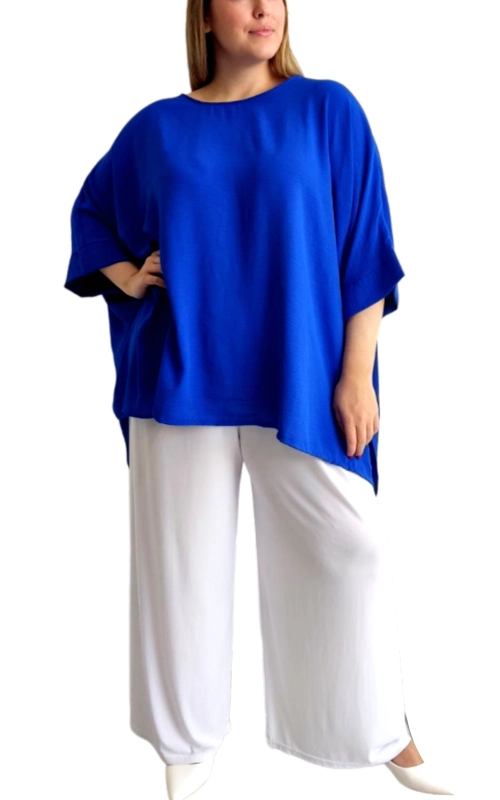 Αυτή η εντυπωσιακή μπλούζα σε έντονο βασιλικό μπλε χρώμα αποτελεί ιδανική επιλογή για κάθε γυναικεία γκαρνταρόμπα. Με φαρδιά γραμμή και χαλαρή εφαρμογή, προσφέρει άνεση και κομψότητα σε κάθε σωματότυπο. Τα φαρδιά μανίκια τύπου νυχτερίδα φτάνουν μέχρι τον αγκώνα, δημιουργώντας μια κολακευτική σιλουέτα που κρύβει τυχόν ατέλειες στην περιοχή των χεριών. Η ασύμμετρη γραμμή στο τελείωμα προσδίδει μοντέρνα πινελιά, ενώ το απλό στρογγυλό λαιμόκοψη ολοκληρώνει το διαχρονικό σχέδιο. Το ελαφρύ, ρέον ύφασμα κινείται αρμονικά με το σώμα, προσφέροντας άνεση όλες τις ώρες της ημέρας. Συνδυάστε την με λευκά παντελόνια όπως στην εικόνα για ένα δροσερό καλοκαιρινό σύνολο, ή με τζιν και αξεσουάρ για πιο casual εμφανίσεις. Ιδανική για καθημερινές εξόδους, γραφείο με χαλαρό dress code ή απογευματινούς καφέδες. Διαθέσιμη σε μεγέθη που κολακεύουν κάθε σιλουέτα.