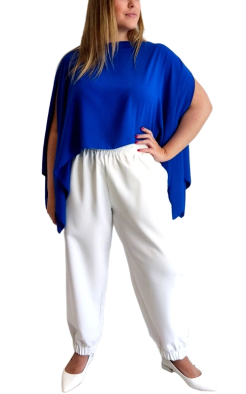 Αυτό το μοντέρνο σετ αποτελείται από μια εντυπωσιακή μπλούζα σε έντονο βασιλικό μπλε χρώμα και ένα άνετο παντελόνι σε λευκό. Η μπλούζα ξεχωρίζει με το φαρδύ, ασύμμετρο σχέδιό της τύπου πόντσο, με ανοίγματα στα πλάγια που δημιουργούν μια αέρινη και κομψή σιλουέτα. Οι χαλαρές γραμμές της προσφέρουν άνεση και στυλ, ενώ το ζωηρό της χρώμα προσθέτει μια νότα φρεσκάδας στο καθημερινό σας ντύσιμο. Το λευκό παντελόνι με το λάστιχο στη μέση και τους αστραγάλους χαρίζει άνεση και ευκολία στην κίνηση, ενώ συμπληρώνει τέλεια το έντονο χρώμα της μπλούζας. Η χαλαρή γραμμή του το καθιστά ιδανικό για πολύωρη χρήση χωρίς να σας περιορίζει. Αυτό το σύνολο είναι ιδανικό για καλοκαιρινές βόλτες, απογευματινούς καφέδες ή ακόμα και για χαλαρές επαγγελματικές συναντήσεις. Συνδυάστε το με λευκά παπούτσια για μια ολοκληρωμένη εμφάνιση ή προσθέστε κοσμήματα σε χρυσές αποχρώσεις για να αναδείξετε ακόμα περισσότερο το έντονο μπλε της μπλούζας.