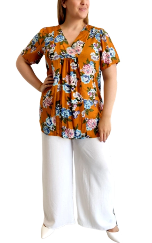 Αυτή η κομψή μπλούζα σε ζωηρό πορτοκαλί ώχρα φόντο αποτελεί την τέλεια επιλογή για το καλοκαιρινό σας γκαρνταρόμπα. Διακοσμημένη με πλούσιο φλοράλ μοτίβο σε αποχρώσεις του γαλάζιου, ροζ και λευκού, προσφέρει μια φρέσκια και θηλυκή εμφάνιση. Ο λαιμός σε σχήμα V και τα κοντά μανίκια εξασφαλίζουν άνεση, ενώ η χαλαρή γραμμή με πιέτες στο μπούστο κολακεύει κάθε σωματότυπο. Η αέρινη υφή της την καθιστά ιδανική για τις ζεστές μέρες, ενώ το φωτεινό της χρώμα θα φωτίσει κάθε σας εμφάνιση. Συνδυάζεται τέλεια με λευκά παντελόνια όπως στη φωτογραφία, αλλά και με τζιν ή φούστες για καθημερινές εξορμήσεις ή χαλαρές βραδινές εξόδους. Η άνετη εφαρμογή της προσφέρει ελευθερία κινήσεων, ενώ το ζωντανό της σχέδιο θα τραβήξει όλα τα βλέμματα. Κατάλληλη για περιστάσεις από πρωινούς καφέδες μέχρι απογευματινούς περιπάτους, αυτή η μπλούζα θα γίνει αγαπημένο κομμάτι της καλοκαιρινής σας γκαρνταρόμπας.